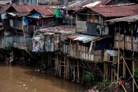 <p>Shanties with hanging toilets, and waste that runs straight into the river below, Jakarta, Indonesia. (Photo: Bay Ismoyo/AFP/Getty Images) </p>