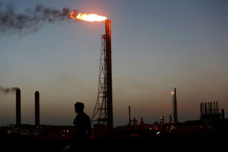 Un hombre pasa cerca de la refinería Cardon, que pertenece a la venezolana PDVSA, en Punto Fijo. 22 de julio de 2016. En agosto del 2015, la estatal Petróleos de Venezuela (PDVSA) hizo pública una de sus mayores licitaciones en los últimos años: un multimillonario proyecto en la Faja del Orinoco, el mayor reservorio de crudo del mundo, diseñado para apuntalar su declinante producción. REUTERS/Carlos Jasso