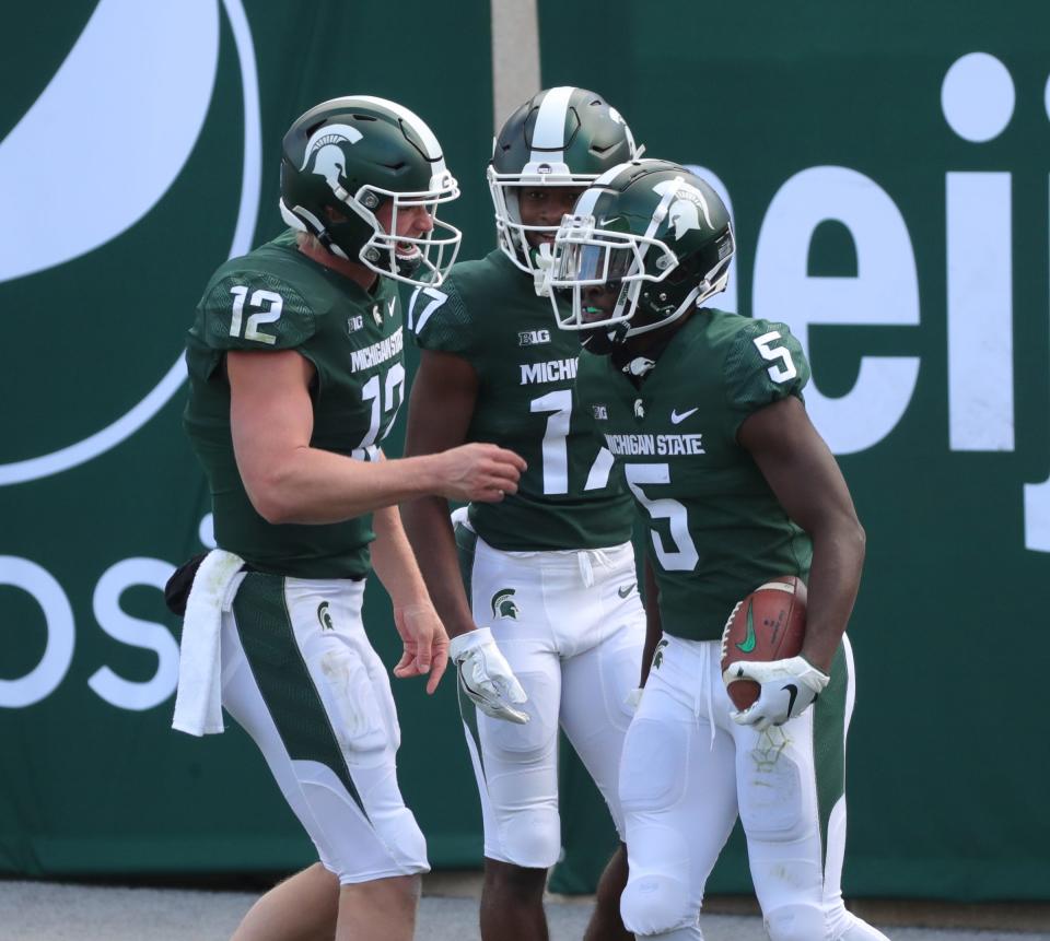 (From left) Michigan State quarterback Rocky Lombardi and wide receiver Tre Mosley congratulate wide receiver Jayden Reed after his touchdown during MSU's 38-27 loss on Saturday, Oct. 24, 2020, at Spartan Stadium.