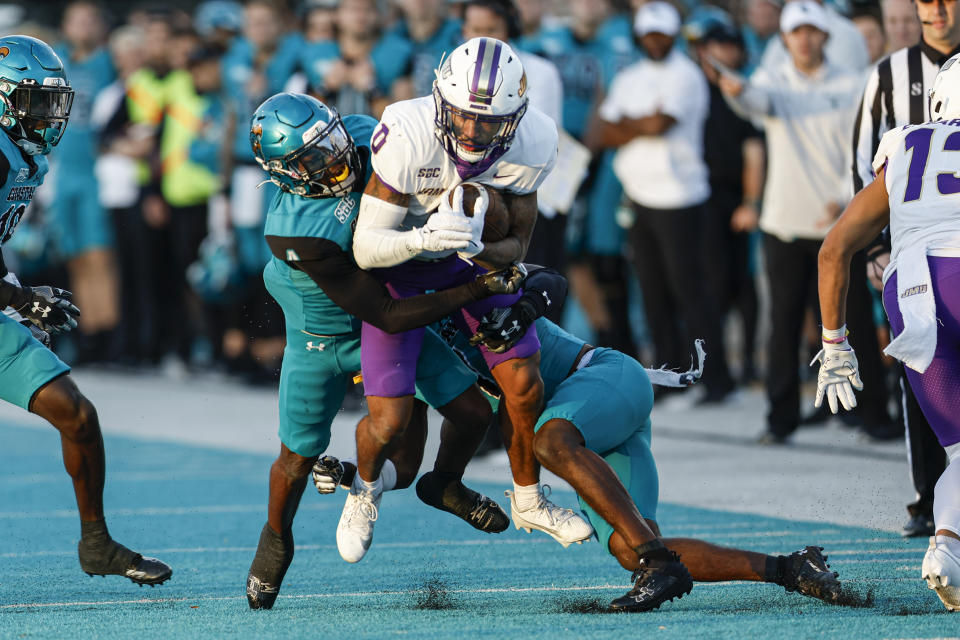 James Madison wide receiver Phoenix Sproles (0) fights for yards after a cat10 against Coastal Carolina during the first half of an NCAA college football game in Conway, N.C., Saturday, Nov. 25, 2023. (AP Photo/Nell Redmond)