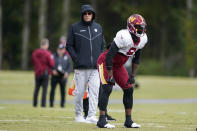 Washington Commanders head coach Ron Rivera, left, watches running back Brian Robinson Jr., works out during practice at the team's NFL football training facility, Wednesday, Oct. 5, 2022, in Ashburn, Va. Robinson was shot twice in the right leg Aug. 28 in Washington, was taken to a hospital, underwent surgery and was released a day later. The bullets missed all the major ligaments and bones in his knee. (AP Photo/Alex Brandon)