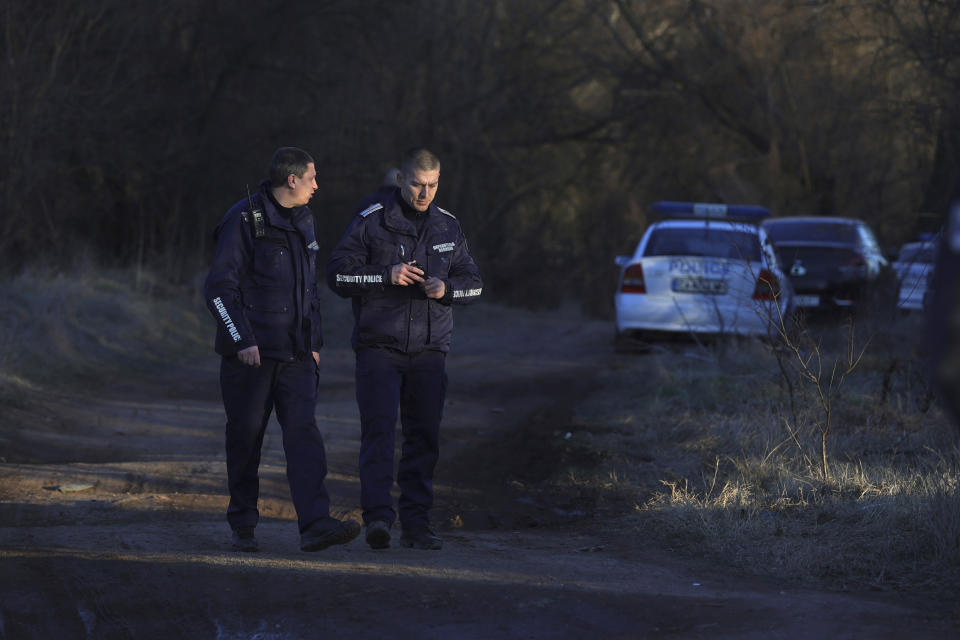 Police officers stand guard at the site where an abandoned truck was found containing the bodies of 18 migrants who appeared to have suffocated to death inside a secret compartment under a load of lumber, in the village of Lokorsko, near Sofia, Bulgaria, Friday, Feb. 17, 2023. The Interior Ministry said that according to initial information, the truck was carrying about 40 migrants and the survivors were taken to nearby hospitals for emergency treatment. (AP Photo/ Valentina Petrova)