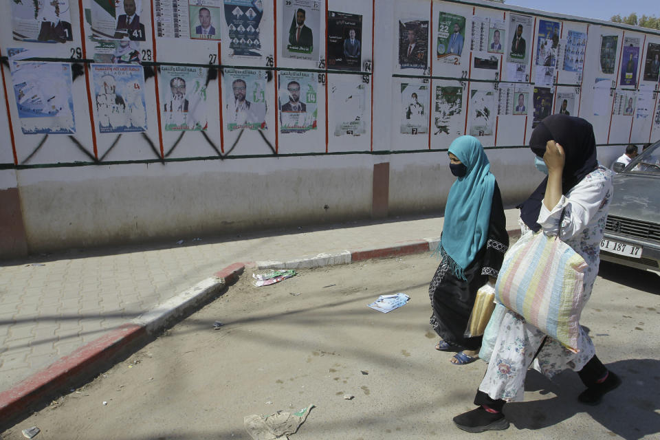 Women walk past electoral posters in Ain Ouessara, 190 kilometers (118 miles) from Algiers, Thursday, June 10, 2021. In addition to the traditional parties, dozens of independent candidates have decided to take part in the legislative elections on June 12, that the government organized earlier than expected under a new system meant to weed out corruption and open voter rolls — a major step in President Abdelmadjid Tebboune's promise of a "new Algeria." (AP Photo/Fateh Guidoum)