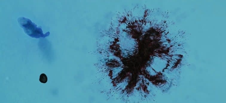 Overhead shot of Dr. Manhattan looking at Rorschach's blood in the snow in "Watchmen"