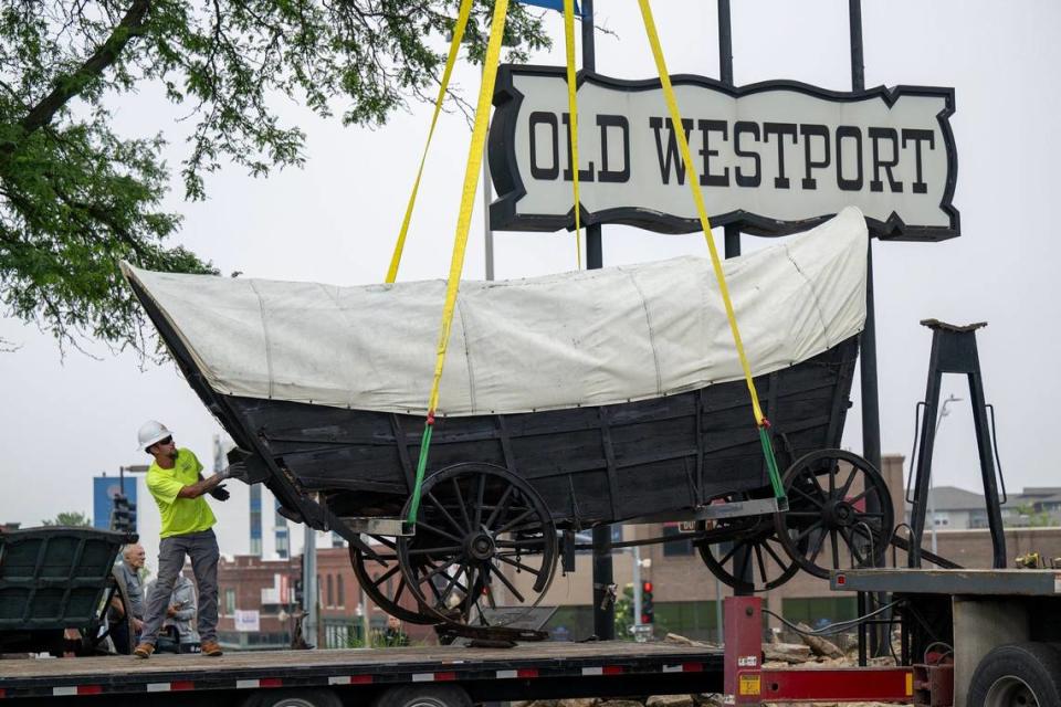Crews worked Wednesday to remove a covered wagon, believed to be from the 1860s, that has stood since 1963 at the Old Westport Shopping Center.