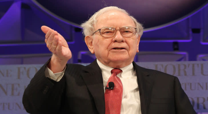 Warren Buffett gestures to an audience.