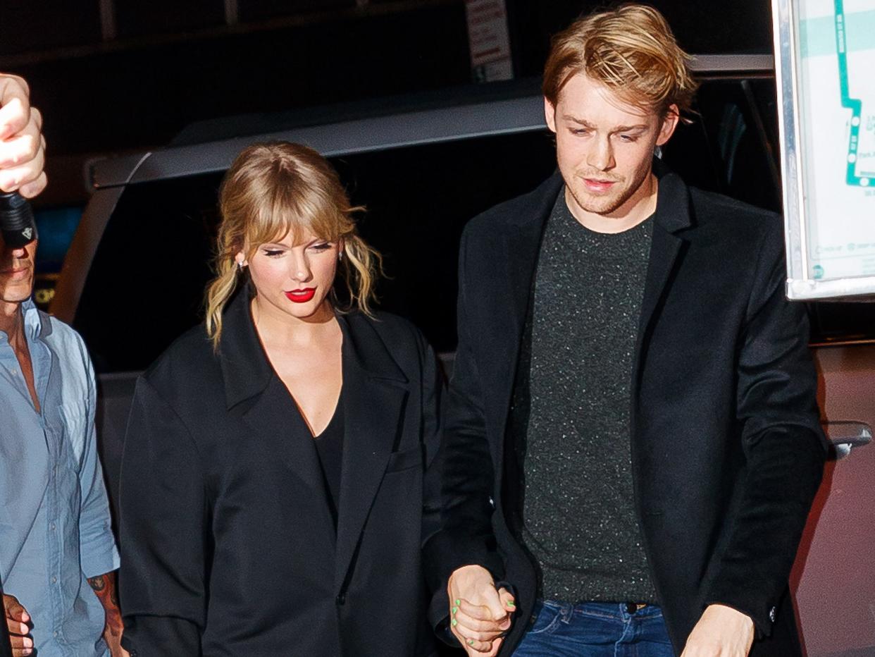 Taylor Swift and Joe Alwyn holding hands.