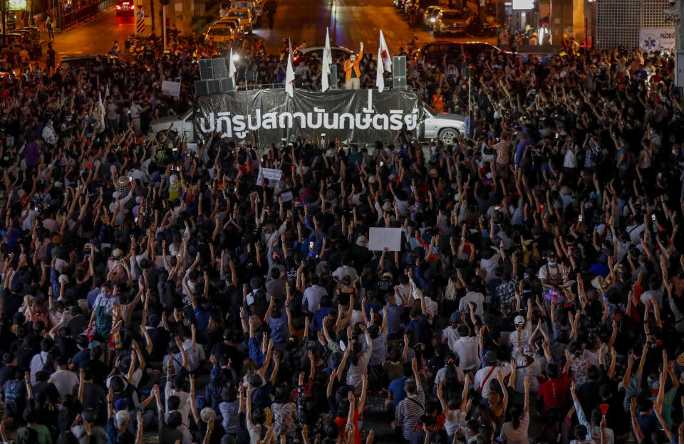 Pro-democracy activists flash a three-fingered symbol of resistance during a rally in Bangkok, Thailand, Wednesday, March 24, 2021, ahead of indictment against 13 protest leaders on Thursday for allegations of sedition and defaming the monarchy. Banner read as "the monarchy's reform." (AP Photo/Sakchai Lalit)