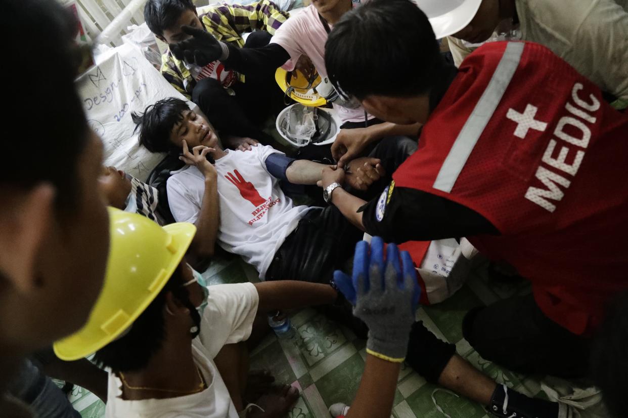 <p>Medics tend to an injured demonstrator during a protest against the military coup in Yangon, Myanmar, on 3 March 2021</p> (EPA)