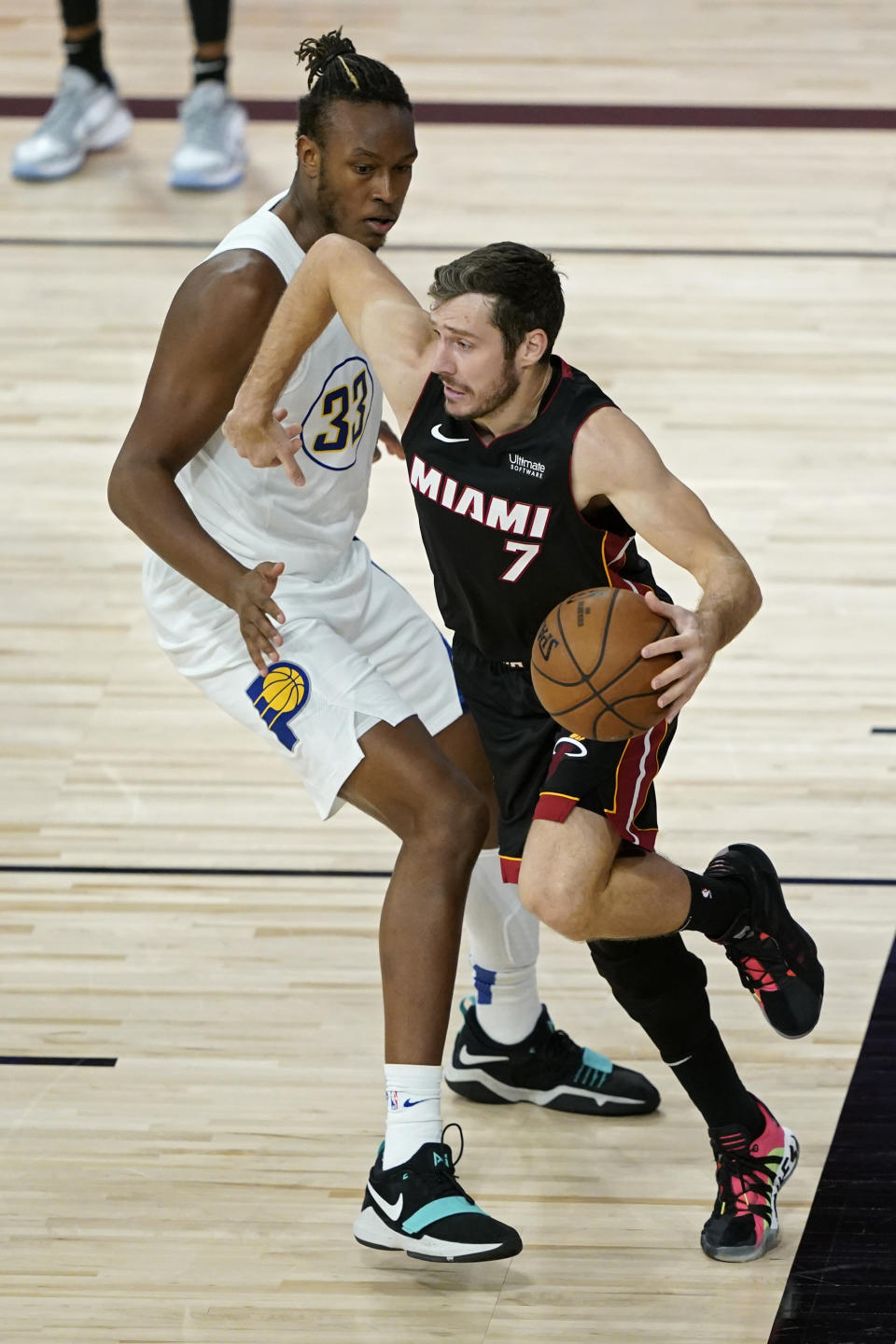 Miami Heat's Goran Dragic (7) drives around Indiana Pacers' Myles Turner (33) during the first half of an NBA basketball first round playoff game Monday, Aug. 24, 2020, in Lake Buena Vista, Fla. (AP Photo/Ashley Landis, Pool)