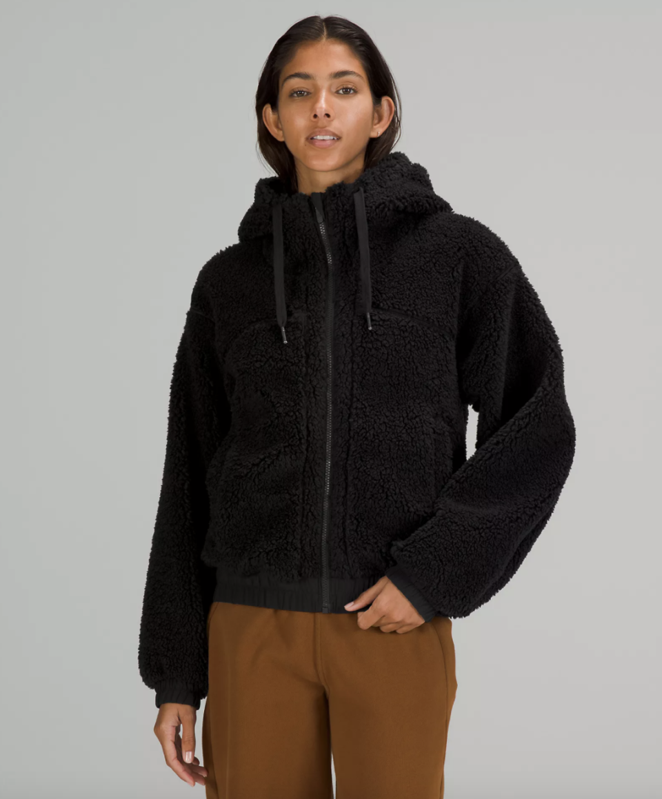 model wearing black lululemon Reversible Fleece Jacket and brown pants