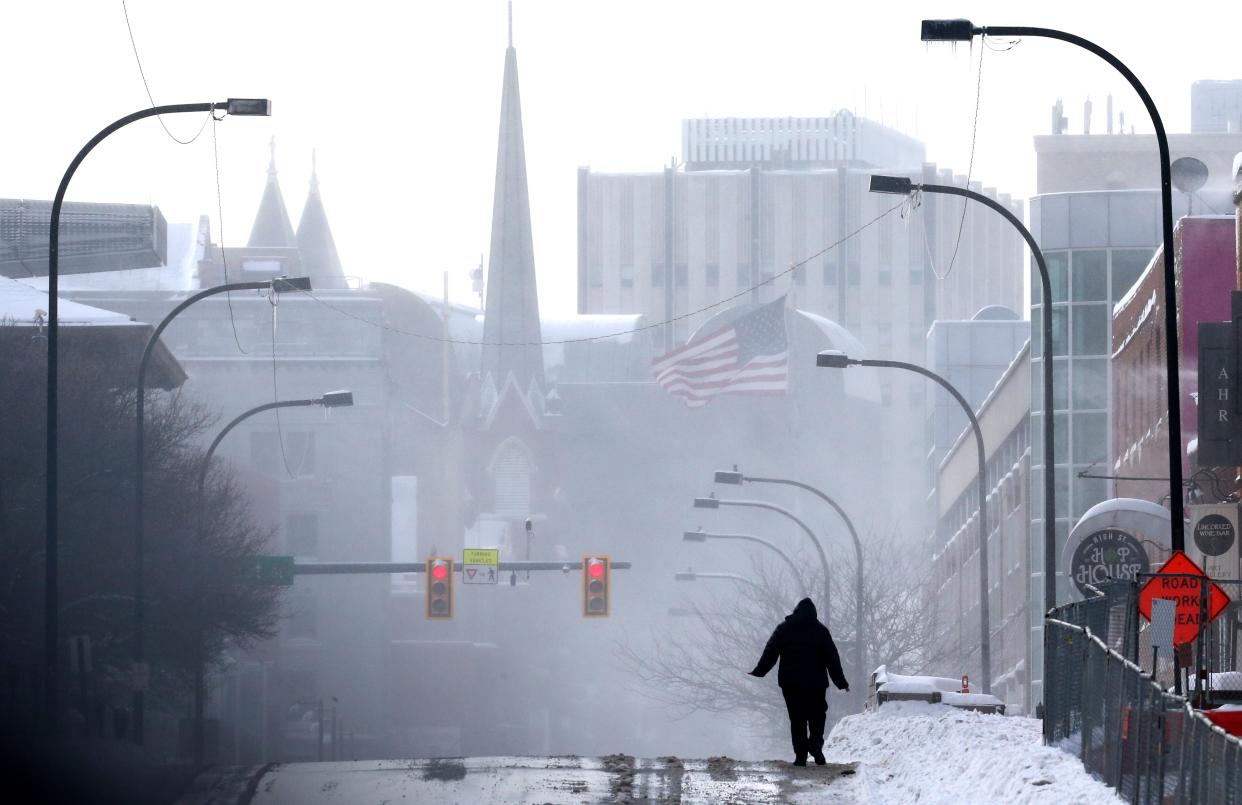 A lone pedestrian walks along High Street in downtown Akron on Monday, Jan. 17.