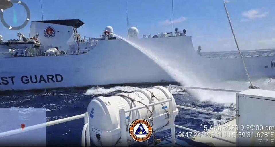 In this handout photo provided by the Philippine Coast Guard, a Chinese coast guard ship uses water canon on a Philippine Coast Guard ship near the Philippine-occupied Second Thomas Shoal, South China Sea as they blocked it's path during a re-supply mission on Saturday Aug. 5, 2023. The Philippine military condemned on Sunday a Chinese coast guard ship's "excessive and offensive" use of a water cannon to block a Filipino supply boat from delivering new troops, food, water and fuel to a Philippine-occupied shoal in the disputed South China Sea. (Philippine Coast Guard via AP)