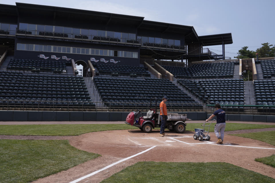 Grounds crew workers chalk the batter's box lines on the field at Holman Stadium, Tuesday, May 23, 2023, in Nashua, N.H. The stadium is being recognized for hosting the country's first racially integrated baseball team, the Nashua Dodgers, in 1946. The club was a minor league league affiliate of the Brooklyn Dodgers, which included Hall of Famer Roy Campanella and future Cy Young Award winner Don Newcombe. (AP Photo/Charles Krupa)