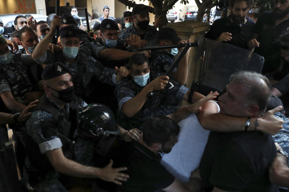 Relatives of people who were killed in last year's massive blast at Beirut's seaport, scuffle with riot police as they tried to storm the home of caretaker Interior Minister Mohamed Fehmi, in Beirut, Lebanon, Tuesday, July 13, 2021. Family members are angry with Fehmi because he rejected a request by the judge investigating the explosion to question Maj. Gen. Abbas Ibrahim, who is one of Lebanon's most prominent generals and heads of the General Security Directorate. (AP Photo/Bilal Hussein)