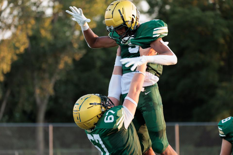 West High's Izaiah Loveless (5) celebrates his touchdown with Luke Ernst (67) during their game against Liberty High at West High on Friday, Aug. 25, 2023. (David Scrivner for the Press-Citizen)