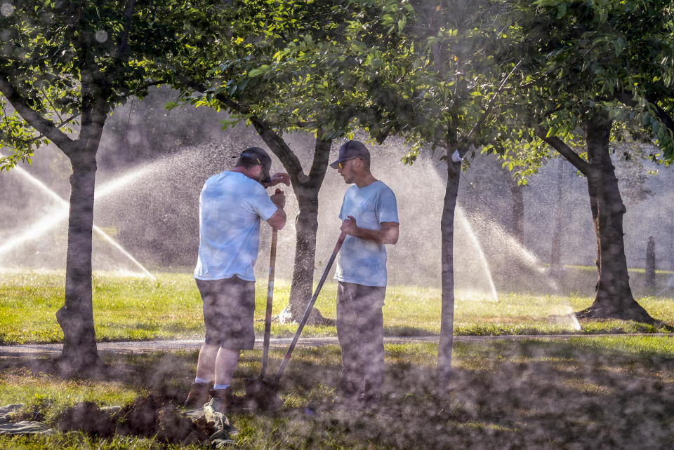 Workmen with the Architect of the Capitol office, perform maintenance on the irrigation system in a park near the Senate, at the Capitol in Washington, Tuesday, June 18, 2024. Extreme heat is expected to break records for tens of millions of people in the United States this week. (AP Photo/J. Scott Applewhite)