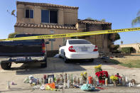 Dozens of candles are laid on the sidewalk, along with bouquets of flowers and stuffed animals outside of a charred home in Riverside, Calif., Wednesday, Nov. 30, 2022. Authorities believe a suspect parked his vehicle in a neighbor's driveway, walked to the home and killed the family members before leaving with a a teenage girl on Friday. Officials have not yet determined how the victims were killed or how the fire was set. The teenager was unharmed. (AP Photo/Amy Taxin)
