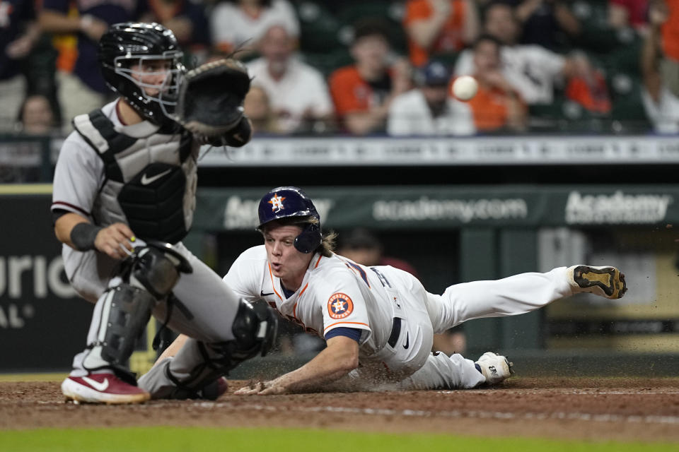 Houston Astros' Jake Meyers, right, scores as Arizona Diamondbacks catcher Daulton Varsho reaches for the ball during the 10th inning of a baseball game Saturday, Sept. 18, 2021, in Houston. (AP Photo/David J. Phillip)