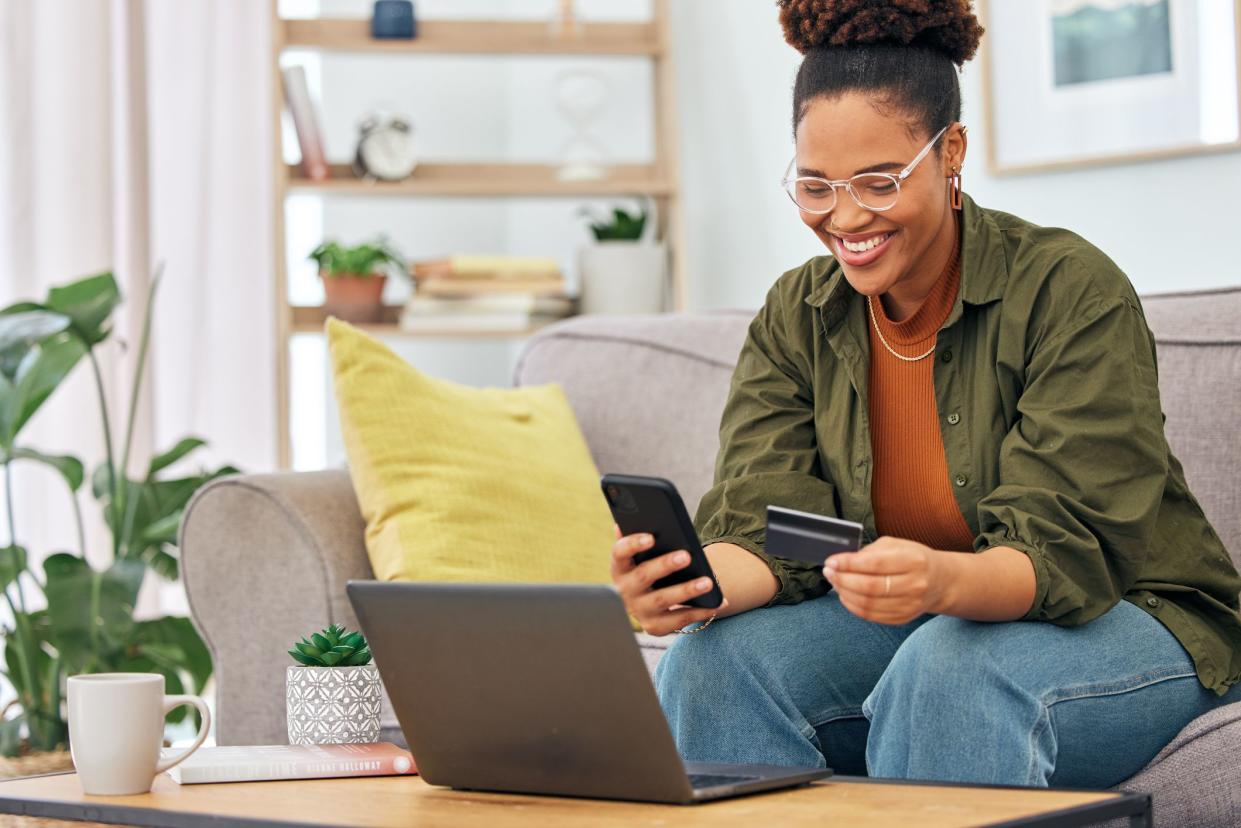 Happy black woman, credit card and online shopping on smartphone for digital payment, fintech account or finance at home. Female person, mobile banking and app for cash, ecommerce technology or money