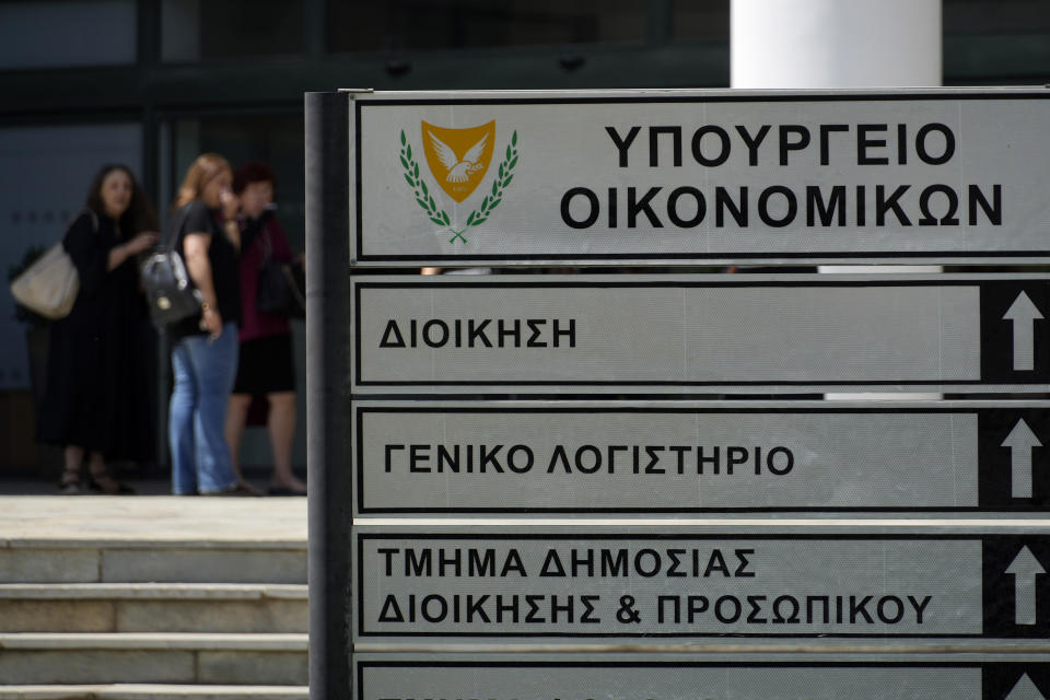 Women stand at the main door of the Ministry of Finance building in capital Nicosia in the eastern Mediterranean island of Cyprus, on Wednesday, June 7, 2023. When the U.S. and U.K. in April included a handful of Cypriot nationals and Cyprus-registered companies as part of another global crackdown on 'enablers' helping Russian oligarchs skirt sanctions, the perception that the island nation somehow remains Moscow's financial lackey again loomed large. (AP Photo/Petros Karadjias)