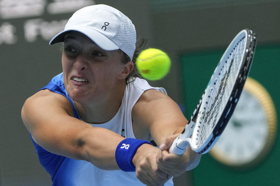 Iga Swiatek of Poland returns a shot to Caroline Garcia of France during the women's singles quarterfinal match in the China Open tennis tournament at the Diamond Court in Beijing, Friday, Oct. 6, 2023. (AP Photo/Andy Wong)