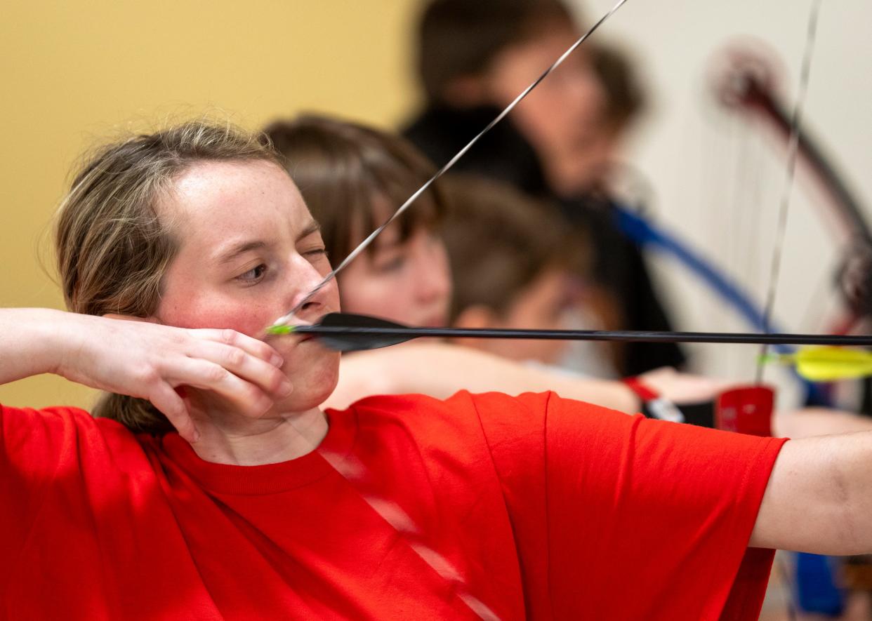 Hannah McMahon, 15, lines up a shot on Tuesday, Feb. 6, in the basement of Scecina Memorial High School. About ten students take part in the after school archery club at the high school, in the Little Flower neighborhood of Indianapolis.