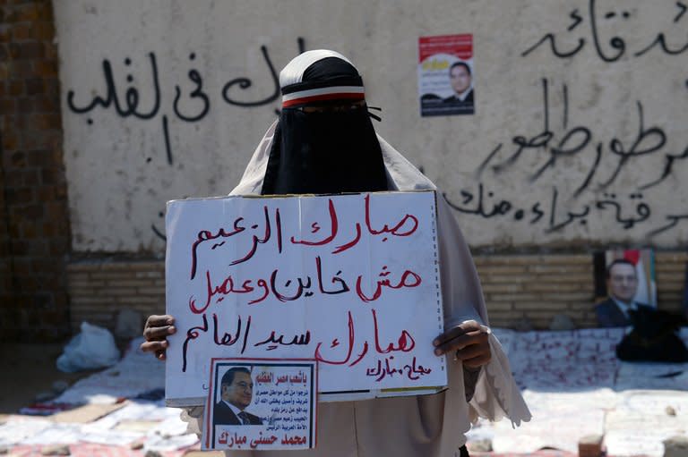 An Egyptian supporter of Egypt's ousted president Hosni Mubarak holds a placard during a demonstration outside the Police Academy in Cairo during his retrial on April 13, 2013. Mubarak appeared in court on Saturday to face a new trial for complicity in the murder of hundreds protesters during the 2011 uprising, as well as for corruption