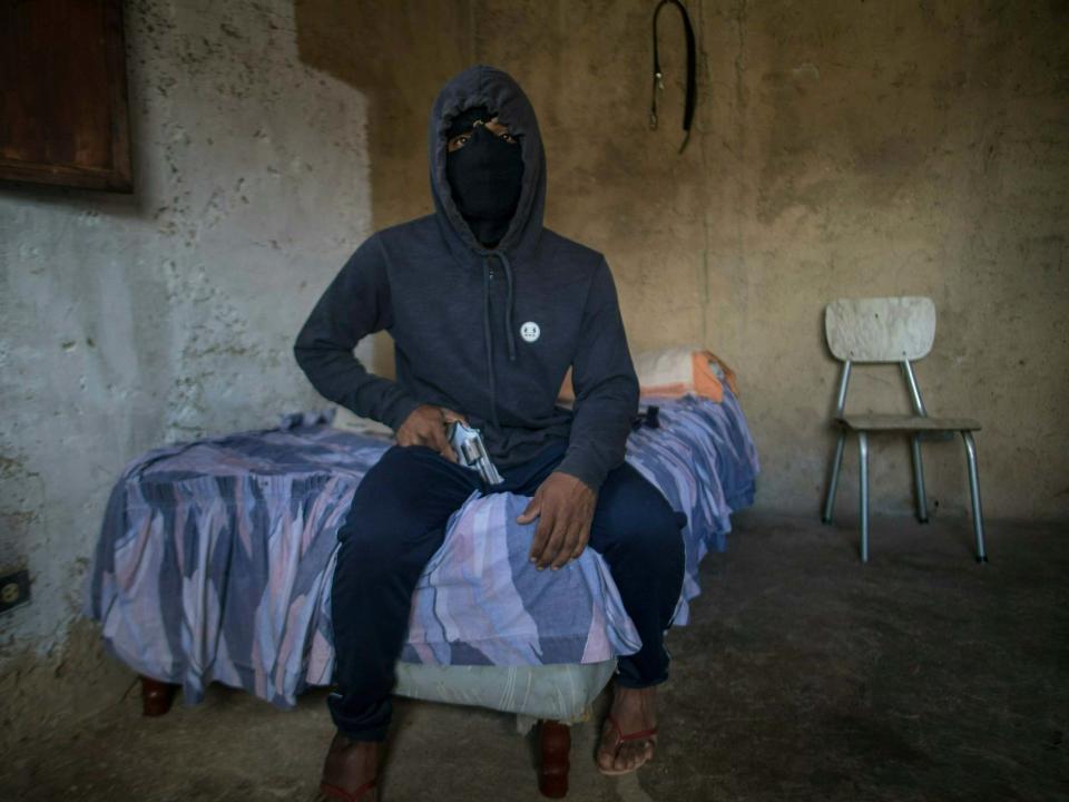 The feared street gangster El Negrito sleeps with a pistol under his pillow and says he has lost track of his murder count. But despite his hardened demeanour, he is quick to gripe about how Venezuela's failing economy is cutting into his profits. Firing a gun has become a luxury. Bullets are expensive at $1 (78p) each and with less cash circulating on the street, he says robberies do not pay like they used to. For the 24-year-old, that has all given way to a simple fact: Even for Venezuelan criminals, it is become harder to get by. "If you empty your clip, you're shooting off $15 (£12)," said El Negrito, who spoke to The Associated Press on the condition he be identified only by his street name and photographed wearing a hoodie and face mask to avoid attracting unwelcome attention."You lose your pistol or the police take it and you're throwing away $800." Officials of President Nicolas Maduro's socialist administration stopped publishing statistics charting crime trends long ago. But in something of an unexpected silver lining to the country's all-consuming economic crunch, experts say armed assaults and killings are plummeting in one of the world's most violent nations.At the Venezuelan Observatory of Violence, a Caracas-based nonprofit group, researchers estimate homicides have plunged up to 20 per cent over the last three years based on tallies from media clippings and sources at local morgues.The decline has a direct link to the economic tailspin that has helped spark a political battle for control of the once-wealthy oil nation.Soaring inflation topped 1 million per cent last year, making the local bolivar nearly useless, even though ATM machines have been unable to dispense more than a dollar's worth of scrip anyway.The severe scarcity of food and medicine has driven some 3.7 million to seek better prospects in places like Colombia, Panama and Peru — the majority of them young males from whom gangs recruit. Workdays are frequently curtailed due to nationwide strikes.But as the country descends into a state of lawlessness, many Venezuelans who turn to crime find themselves subject to the same chaos that has led to a broader political and social meltdown.Critics blame 20 years of the socialist revolution launched by the late President Hugo Chavez, who expropriated once-thriving businesses that today produce a fraction of their potential under government management.Earlier this year, opposition leader Juan Guaido launched a bold campaign with the support of the US and more than 50 nations to oust Mr Maduro, who succeeded Chavez.However, Mr Guaido has yet to make good on his promises to restore democracy, spark a robust economy and make the streets safer. As a result of the chaos, crime has not so much disappeared as simply morphed in form. While assaults are down, reports of theft and pilfering of everything from copper telephone wires to livestock are surging.Meanwhile, drug trafficking and illegal gold mining have become default activities for organised crime.When night falls, streets in Caracas clear as most residents abide by an undeclared curfew out of fear for their safety. Despite the significant drop in killings, Venezuelans tend not to gaze at their mobile phones in the streets. Many leave gold and silver wedding rings in secure places at home, while others have grown accustomed to checking whether they are being followed. "Venezuela remains one of the most violent countries in the world," said Dorothy Kronick, who teaches political science at the University of Pennsylvania and has carried out extensive research in Caracas' slums. "It has wartime levels of violence — but no war." El Negrito leads for-hire hoodlums called the Crazy Boys, a band that forms part of an intricate criminal network in Petare, one of Latin America's largest and most feared slums.The gangster, who agreed to an interview with two associates at their hillside hideout in Caracas, said his group now carries out roughly five kidnappings a year, down considerably from years past. Such express abductions are big business. Typically, a victim is nabbed and held hostage for up to 48 hours while loved ones scramble to gather as much cash as they can find, with kidnappers focused on speed and a quick return rather than on the size of the payout. El Negrito said the ransom they set depends on what a victim's car costs and a deal can turn deadly if demands are not met. But like many of his associates, he has considered leaving the trade in Venezuela and emigrating. He said some people have quit the world of crime and sought more honest work abroad, fearing stiff penalties in other countries where laws are more enforced. While explaining that he struggles to support his wife and young daughter, El Negrito passed a silver pistol between his hands. A Bible lay open to Proverbs on a dresser as a breeze turned the pages. Robert Briceno, director of the Venezuelan Observatory of Violence, said the decline in homicides is a matter of basic economics: As cash becomes scarce in Venezuela, there is less to steal. "These days, nobody is doing well — not honest citizens who produce wealth or the criminals who prey on them," he said. One associate of the Crazy Boys, who gave only his nickname, Dog, said he has no trouble finding ammunition for his guns on the black market. He said the challenge is paying for them in a country where the average person earns $6.50 a month. "A pistol used to cost one of these bills," he said, crumbling up a 10 bolivar bill that can no longer be used to buy a single cigarette. "Now, this is nothing."Associated Press