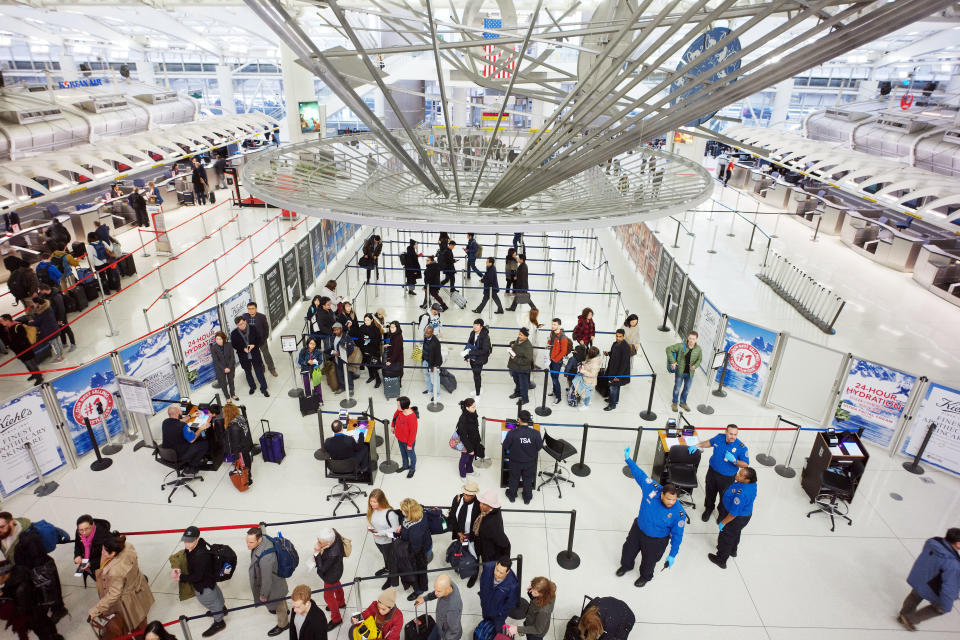 Passengers wait to pass through a TSA security checkpoint