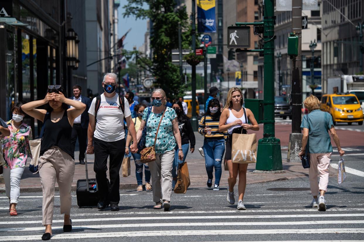 People walk down 5th Avenue on a warm day on June 7, 2021 in New York City. (Photo by Angela Weiss / AFP) (Photo by ANGELA WEISS/AFP via Getty Images)