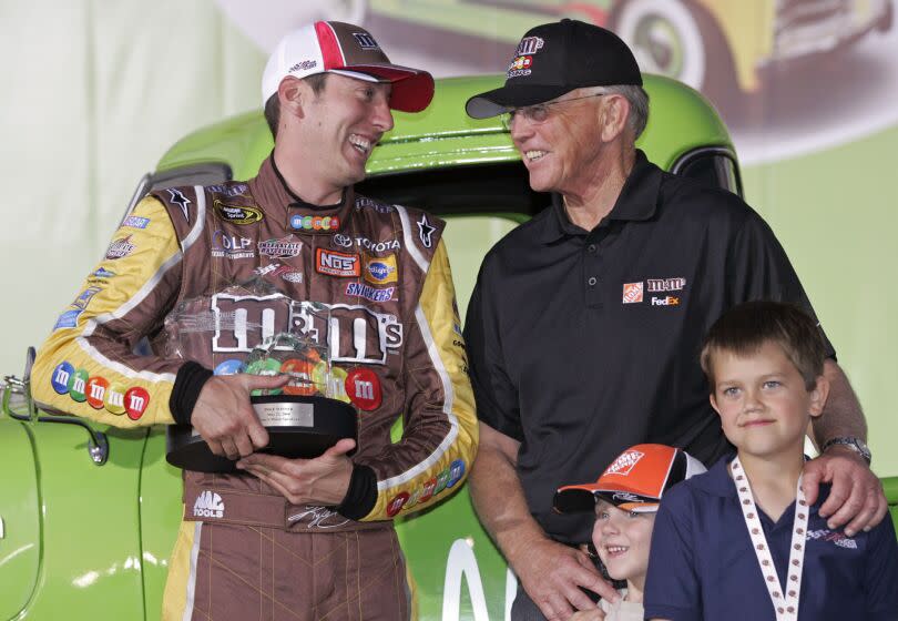 FILE - Kyle Busch, left, jokes with team owner Joe Gibbs, right, in victory lane after winning the pole position.