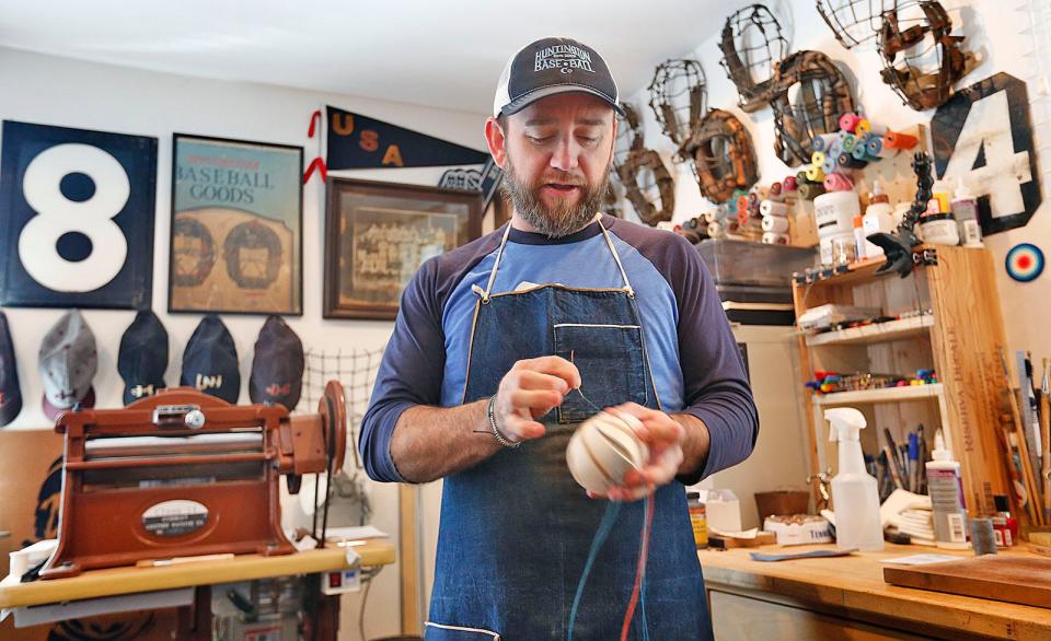 William Peebles hand makes baseballs, bats, wallets and more in the Norwell studio of Huntington Base Ball Co. Wednesday, Nov. 2, 2022. The balls are hand stitched one at a time, some feature custom logos and others are replicas of the first balls used in the 1860's.