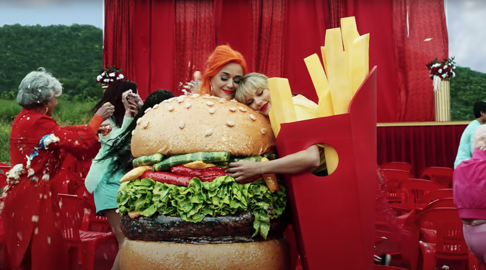 Katy Perry in a hamburger suit is hugged by Taylor Swift in french fry suit in the "You Need to Calm Down" music video