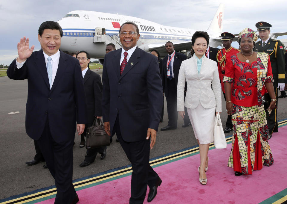 In this photo released by China's Xinhua News Agency, Chinese President Xi Jinping, left, and his wife Peng Liyuan, second right, are welcomed by Tanzanian President Jakaya Mrisho Kikwete, second left, and his wife Salma Kikwete, right, upon their arrival in Dar es Salaam, Tanzania, Sunday, March 24, 2013. Glamorous new first lady Peng has emerged as a Chinese diplomatic star, charming audiences and cutting a distinct profile from her all-but-invisible predecessors on her debut official trip abroad. (AP Photo/Xinhua, Lan Hongguang) NO SALES