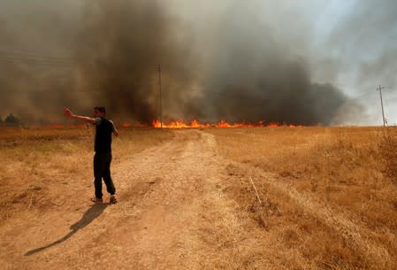 Iraqi man asks for help to put out a fire in Bashiqa, east of Mosul