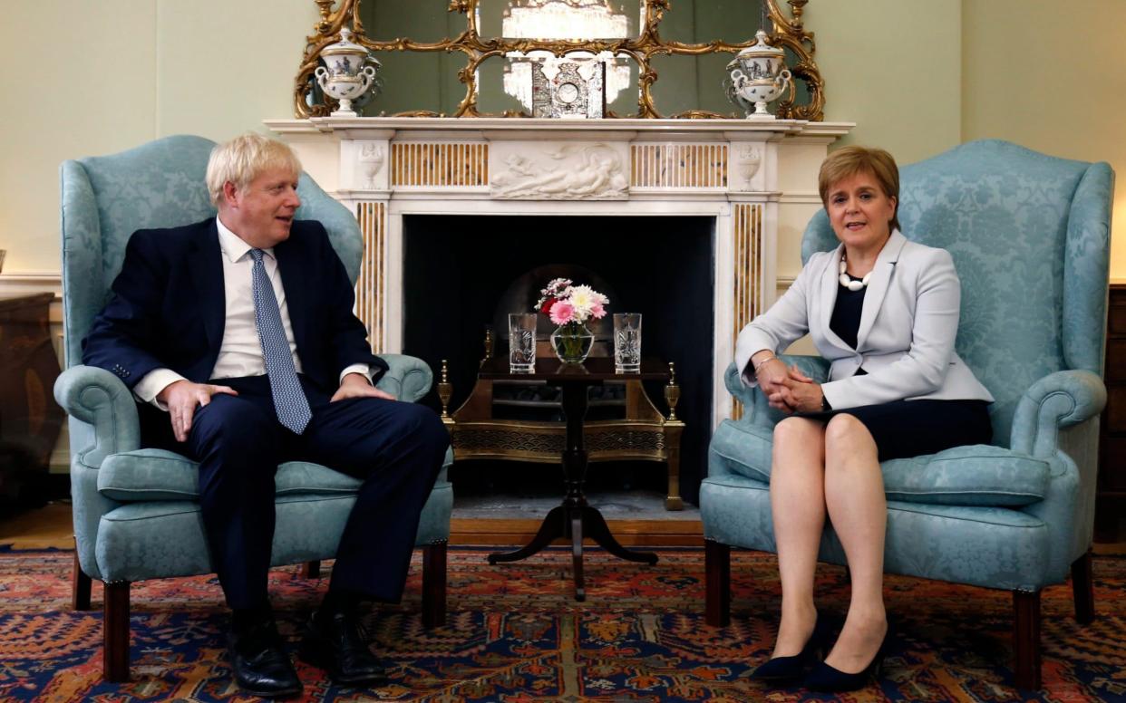 Scotland's First Minister Nicola Sturgeon, right, sits with Britain's Prime Minister Boris Johnson, - Duncan McGlynn/Pool Getty