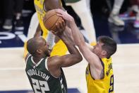 Milwaukee Bucks' Khris Middleton (22) is fouled by Indiana Pacers' T.J. McConnell (9) during the first half of Game 4 of the first round NBA playoff basketball series, Sunday, April 28, 2024, in Indianapolis. (AP Photo/Michael Conroy)