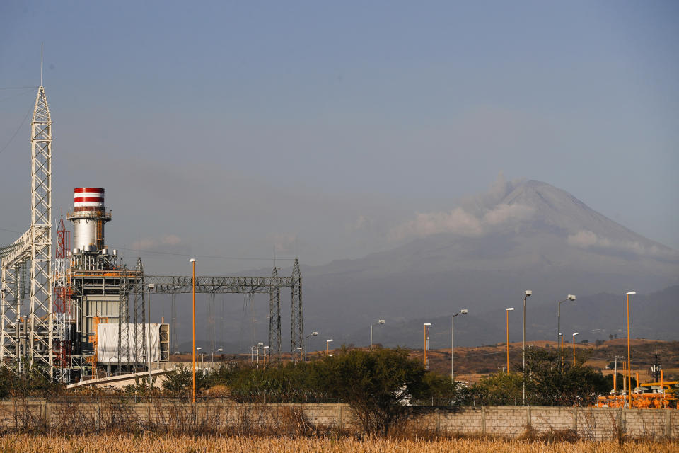 A newly built power generation plant stand idle with the Popocatepetl Volcano in the background, near Huexca, Morelos state, Mexico, Saturday, Feb. 22, 2020. Dozens of mostly indigenous communities along the 159 kilometers of pipeline have united to fight the mega-project they believe will deprive them of water for their crops, while contaminating the soil and air. (AP Photo/Eduardo Verdugo)