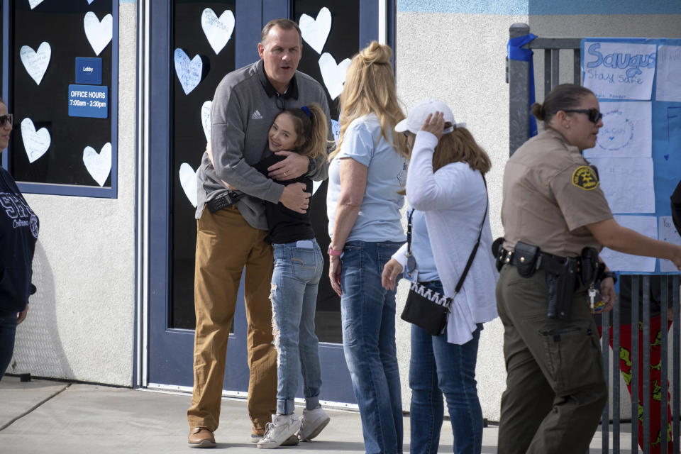 Saugus high principal Vince Ferry gives hugs and welcomes students back on campus Tuesday, Nov. 19, 2019. Students were allowed back to collect their belongings left behind after the tragic shooting last Thursday. Classes will resume at the high school on Dec. 2. (David Crane/The Orange County Register via AP)