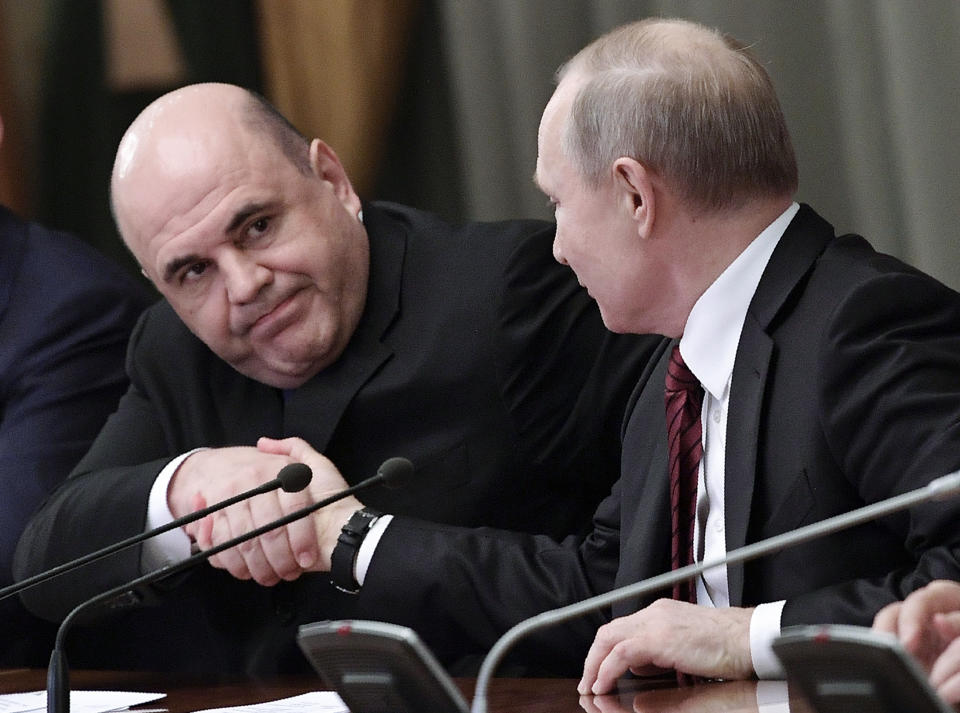 Russian President Vladimir Putin, right, and new Russian Prime Minister Mikhail Mishustin shake hands during a new cabinet meeting in Moscow, Russia, Tuesday, Jan. 21, 2020. Putin formed his new Cabinet Tuesday, replacing many of its members but keeping his foreign, defense and finance ministers in place. (Alexei Nikolsky, Sputnik, Kremlin Pool Photo via AP)