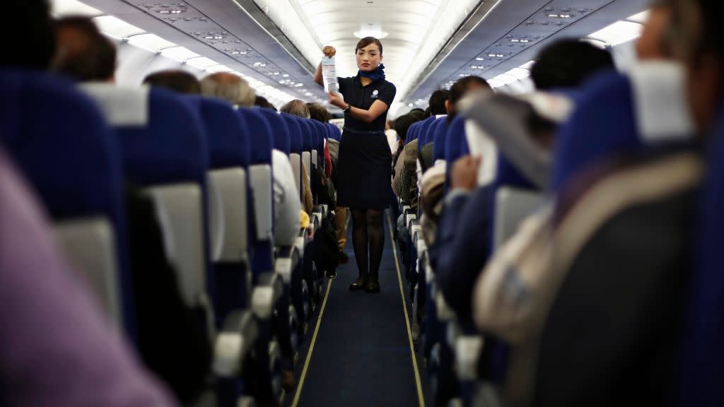 An Indigo Airlines' cabin crew member goes over safety guidelines during a flight