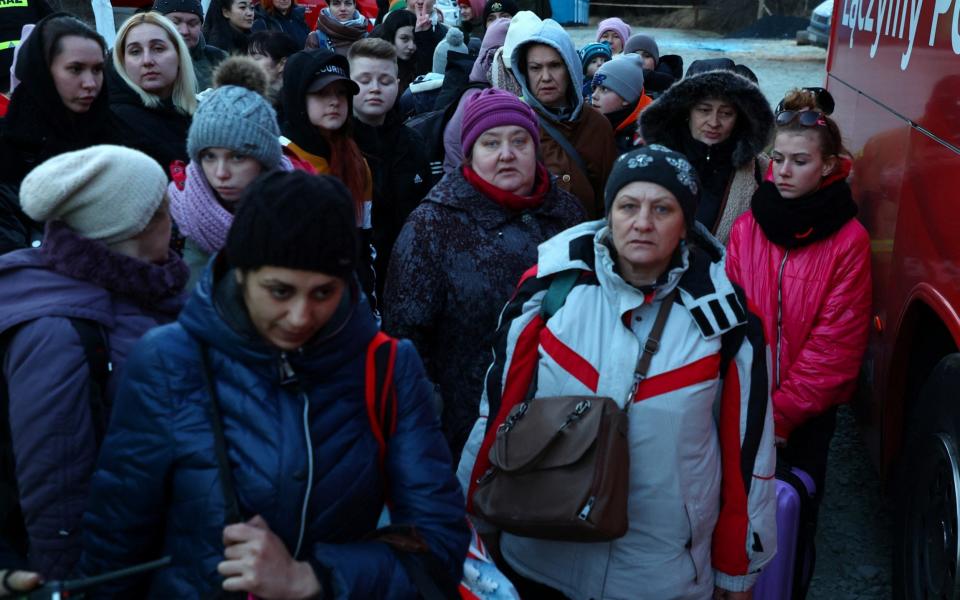 Refugees from Ukraine wait to board a bus to Warsaw after crossing the border from Ukraine to Poland, fleeing the Russian invasion of Ukraine, at border checkpoint in Kroscienko, Poland, March 17, 2022.  - REUTERS/Fabrizio Bensch