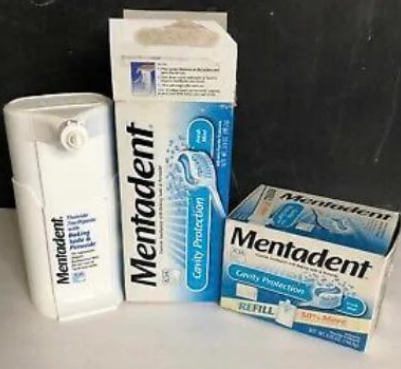 Photo of a Mentadent toothpaste dispenser and refill boxes
