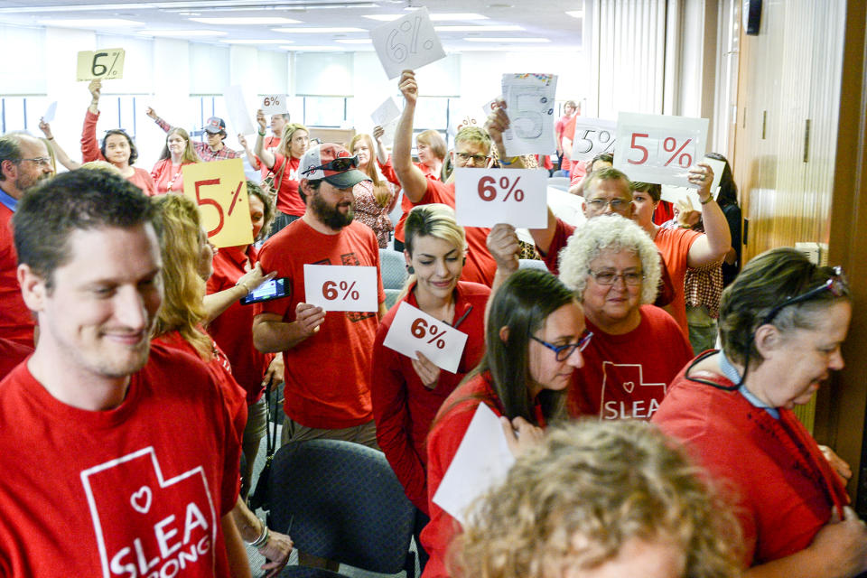 In this June 4, 2019 photo, teachers walk out of the public comment period at the Salt Lake City School District meeting regarding salary negotiations, in Salt Lake City. Across the country, teachers and school districts alike are grappling with the latest political and economic realities of educator pay. (Leah Hogsten/The Salt Lake Tribune via AP)