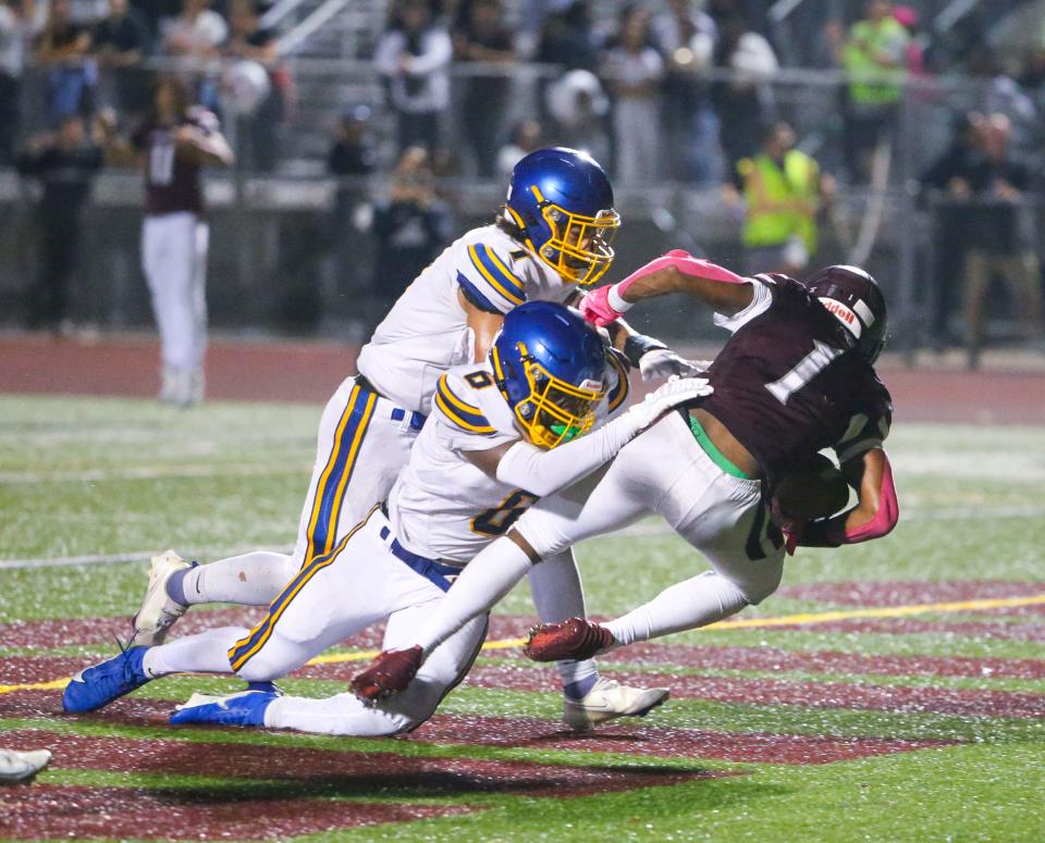 Appoquinimink's Dillon Griffith (1) holds on to the eventual game-winning touchdown reception as he is hit by Sussex Central defenders William Harmon (7) and Jajuan Sturgis in the fourth quarter of Appoquinimink's 31-30 comeback win at home, Friday, Oct. 6, 2023.