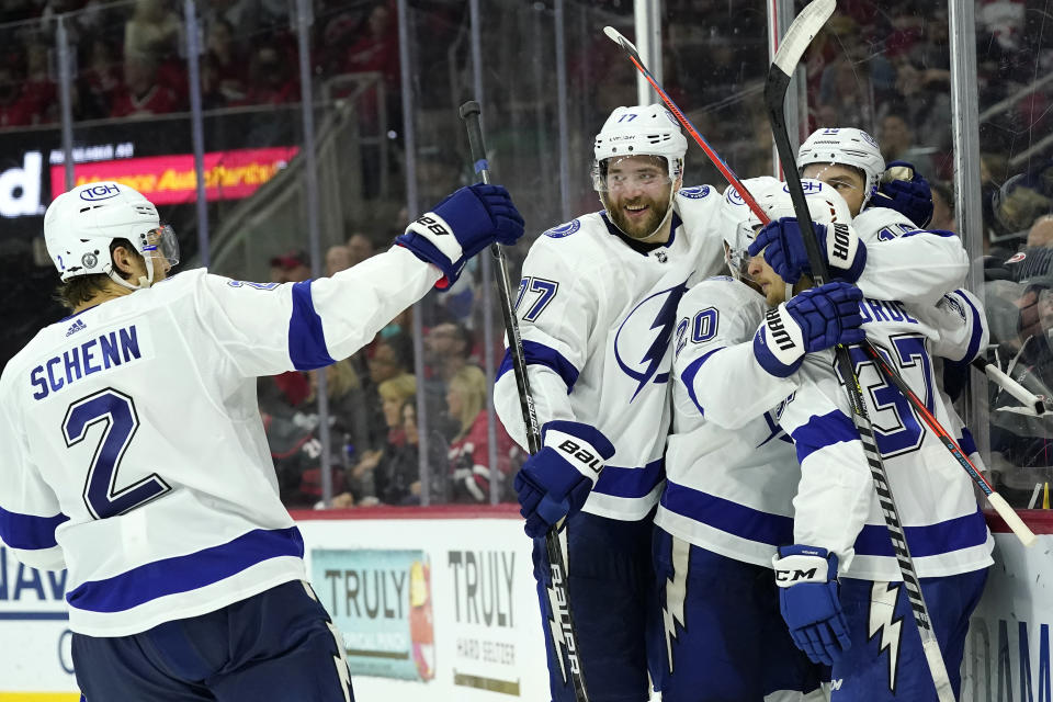 Tampa Bay Lightning defenseman Luke Schenn (2) congratulates center Barclay Goodrow, right, along with defenseman Victor Hedman (77), center Yanni Gourde (37) and center Blake Coleman (20) following Goodrow's goal during the third period in Game 1 of an NHL hockey Stanley Cup second-round playoff series against the Carolina Hurricanes in Raleigh, N.C., Sunday, May 30, 2021. (AP Photo/Gerry Broome)