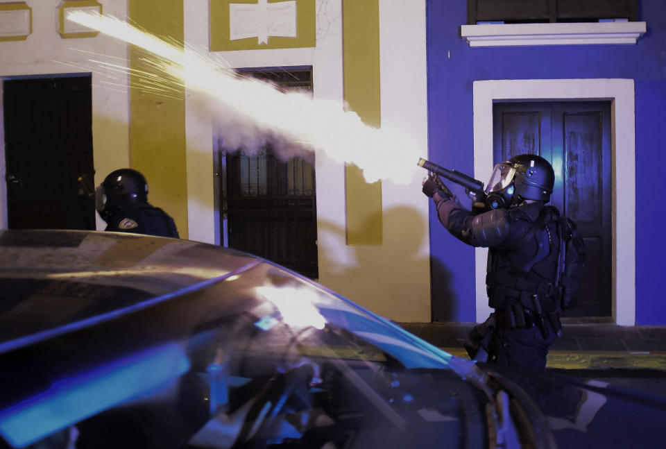 Police units launch tear gas to control several riots near the executive mansion while demonstrators demand the resignation of Gov. Ricardo Rossello in San Juan, Puerto Rico, Monday, July 22, 2019. Protesters are demanding Gov. Ricardo Rossello step down following the leak of an offensive, obscenity-laden online chat between him and his advisers that triggered the crisis. (AP Photo/Carlos Giusti)