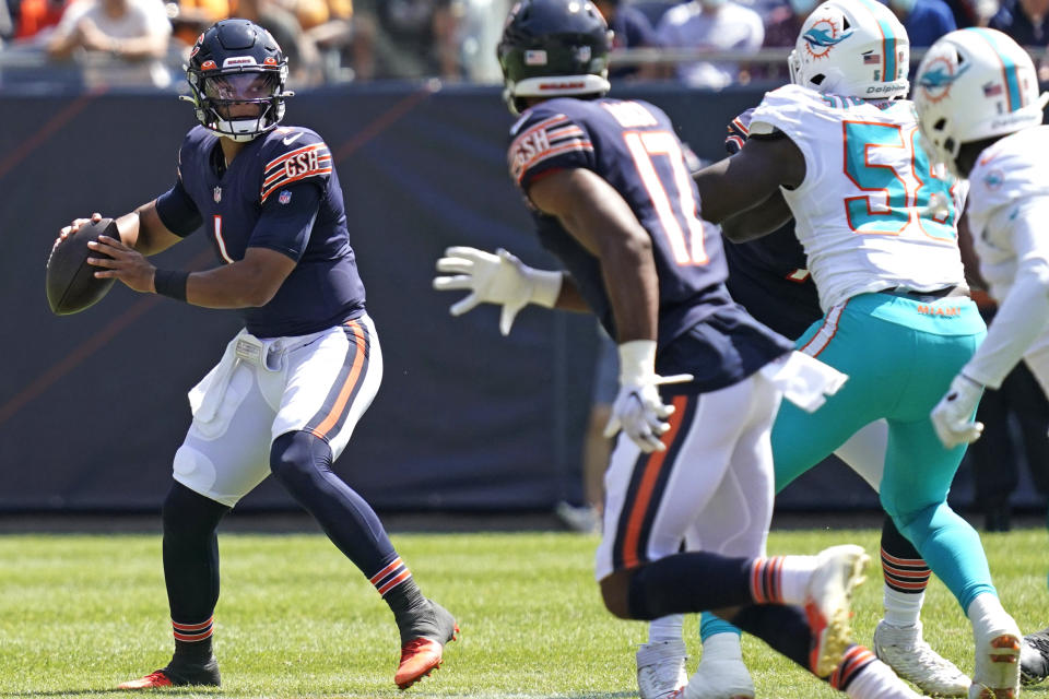 Chicago Bears quarterback Justin Fields, left, prepares to throw the ball against the Miami Dolphins during the second half of an NFL preseason football game in Chicago, Saturday, Aug. 14, 2021. (AP Photo/Nam Y. Huh)