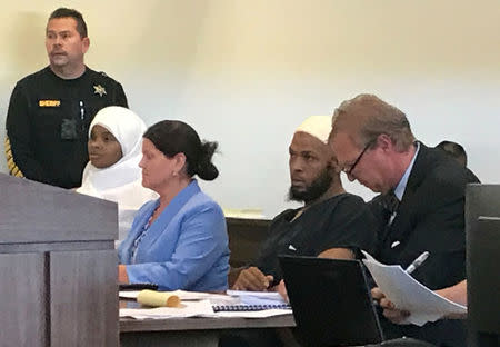 Defense attorney Thomas Clark (R) sits next to his client, defendant Siraj Ibn Wahhaj, defense attorney Marie Legrand Miller (2nd L) and her client Hujrah Wahhaj (L) during a hearing on charges of child abuse in which they were granted bail in Taos County, New Mexico, U.S. August 12, 2018. Picture taken August 12, 2018. REUTERS/Andrew Hay